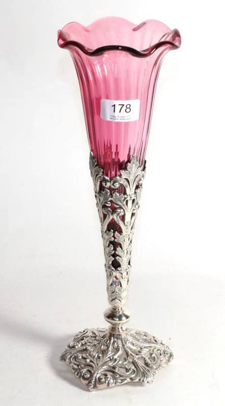 Lot 178 - A large electroplated and cranberry glass vase, the cast base decorated with scrolling foliage,...
