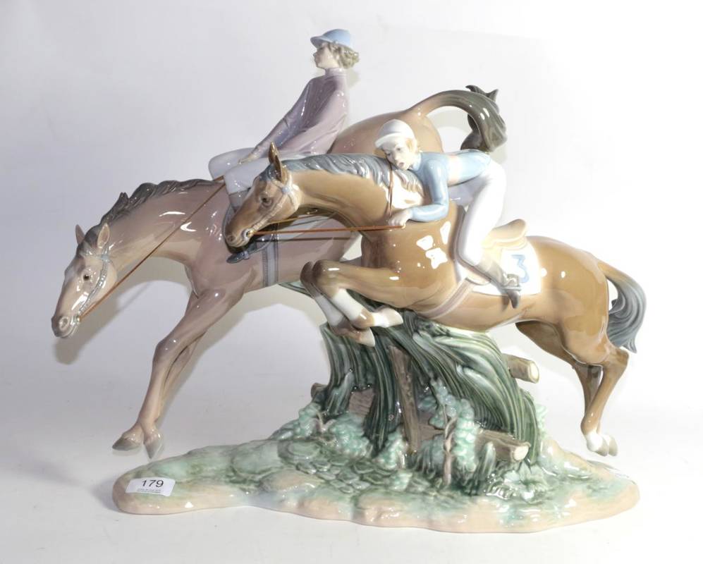 Lot 179 - A large and rare Lladro figure group of jockeys and race horses jumping a fence, impressed mark...