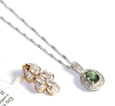 Lot 235 - A 9 carat white gold green tourmaline and diamond pendant on a 9 carat white gold chain, chain...