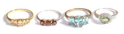 Lot 242 - Four 9 carat gold gem set dress rings including a blue zircon three stone example, a cinnamon...