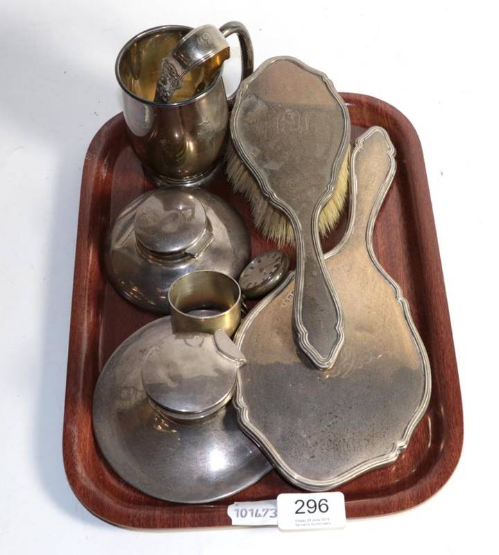 Lot 296 - A group of silver comprising: christening mug, napkin ring, sugar tongs, two capstan inkwells, hand