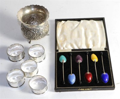 Lot 302 - A set of six enamel coffee spoons in fitted case; five silver napkin rings; and a footed vase