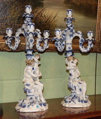 Lot 338 - A pair of Continental, figural, blue and white candelabra