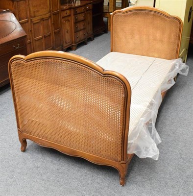 Lot 1174 - A French walnut bergere single bedstead   Purchased from Liberty & Co, London