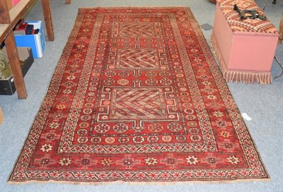 Lot 1210 - Kurdish lon rug, the crimson field with three crenolated panels enclosed by stellar motif...