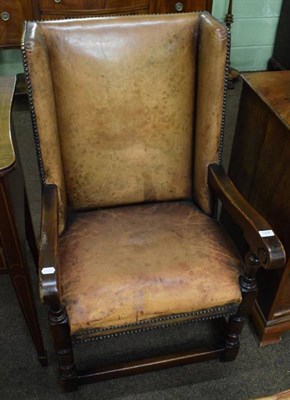 Lot 1296 - An early 20th century leather wingback armchair