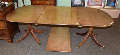 Lot 1298 - A 20th century twin pedestal dining table with two additional leaves