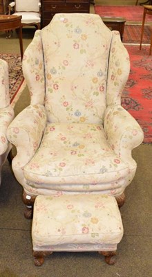 Lot 1315 - A 1950s Epstein wing back armchair with floral upholstery and matching footstool