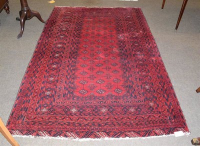 Lot 1230 - An Afghan Turkmen rug, the crimson field with columns of guls enclosed by multiple borders,...