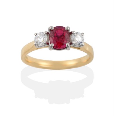 Lot 16 - An 18 Carat Gold Ruby and Diamond Three Stone Ring, the oval mixed cut ruby flanked by two...
