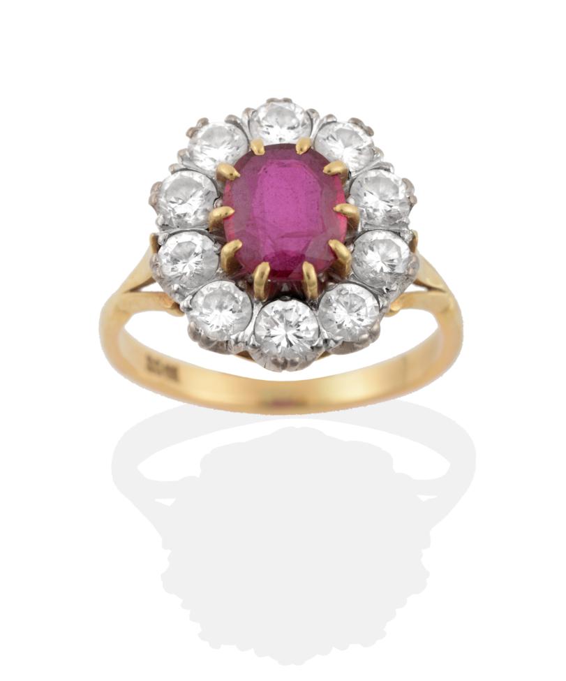Lot 18 - A Ruby and Diamond Cluster Ring, an oval cut ruby in yellow claw settings, within a border of round