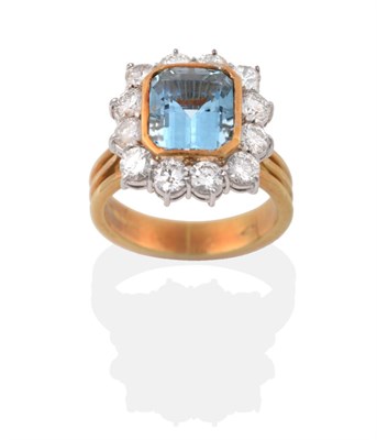 Lot 30 - An 18 Carat Gold Aquamarine and Diamond Cluster Ring, an emerald cut aquamarine in a yellow...