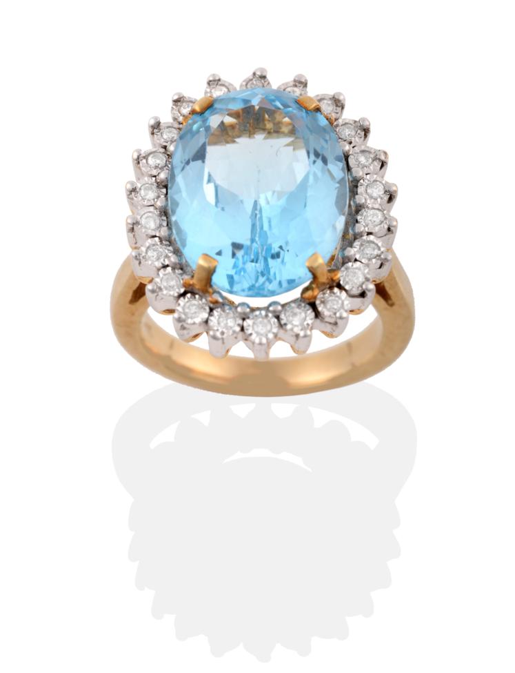 Lot 32 - A 9 Carat Gold Blue Topaz and Diamond Cluster Ring, an oval cut topaz in a yellow four claw...