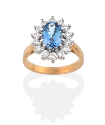 Lot 33 - An 18 Carat Gold Aquamarine and Diamond Cluster Ring, an oval cut aquamarine within a border of...