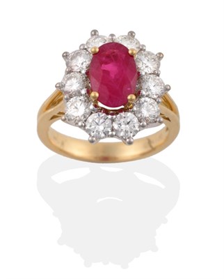 Lot 39 - An 18 Carat Gold Ruby and Diamond Cluster Ring, an oval mixed cut ruby in a yellow four claw...