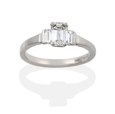 Lot 74 - A Platinum Diamond Three Stone Ring, a central emerald-cut diamond in a four claw setting,...