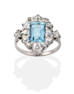 Lot 76 - An Aquamarine and Diamond Cluster Ring, the baguette cut aquamarine within a border of old cut...