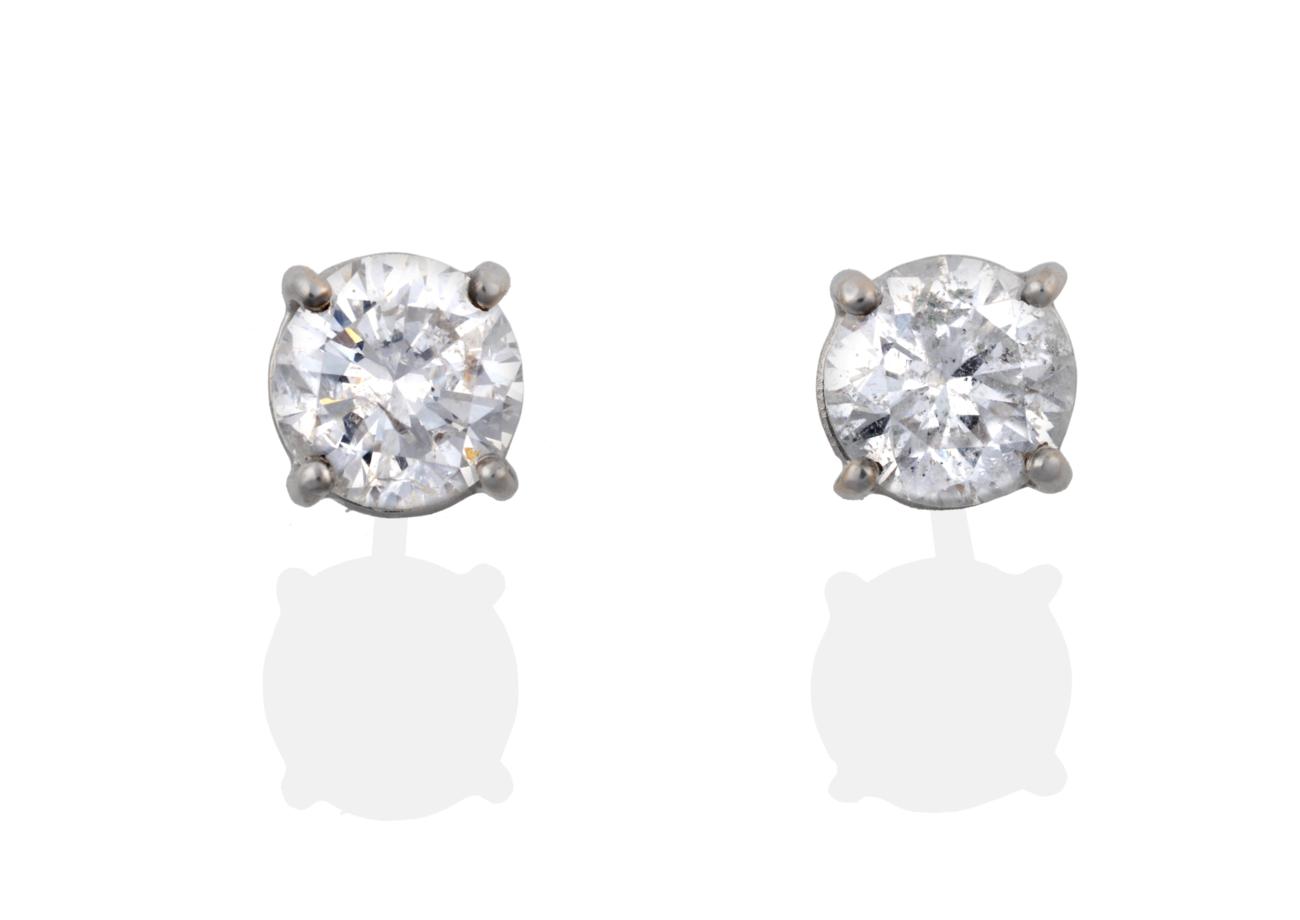 Lot 77 - A Pair of 18 Carat White Gold Diamond Solitaire Earrings, the round brilliant cut diamonds in...