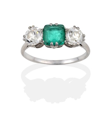 Lot 80 - An Emerald and Diamond Three Stone Ring, the octagonal step cut emerald flanked by two old cut...