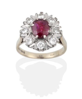 Lot 83 - An 18 Carat White Gold Ruby and Diamond Cluster Ring, an oval cut ruby within a border of round...