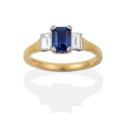 Lot 96 - An 18 Carat Gold Sapphire and Diamond Three Stone Ring, the octagonal step cut sapphire flanked...
