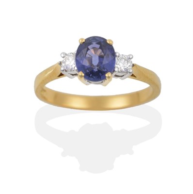 Lot 102 - An 18 Carat Gold Sapphire and Diamond Three Stone Ring, the oval cut sapphire sits between two...