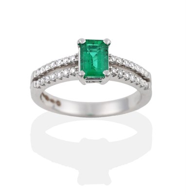 Lot 106 - An 18 Carat White Gold Emerald and Diamond Ring, the emerald-cut emerald in a four claw setting, to
