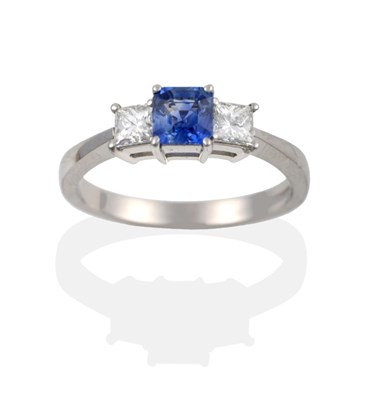 Lot 109 - A Platinum Sapphire and Diamond Three Stone Ring, the square octagonal step cut sapphire...