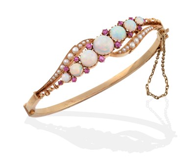 Lot 121 - An Opal, Ruby and Seed Pearl Bangle, graduated round cabochon opals spaced by pairs of round...
