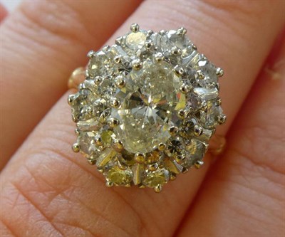 Lot 127 - A Diamond Cluster Ring, an oval cut diamond within a border of round brilliant cut diamonds and...