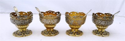 Lot 1097 - A Set of Four Victorian Silver Gilt Salt Cellars and Spoons, Charles Edwards, London 1893, the cast