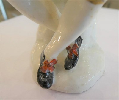 Lot 510 - A Bow Porcelain Commedia dell'Arte Figure of Harlequin, circa 1755, sitting on a rock playing...