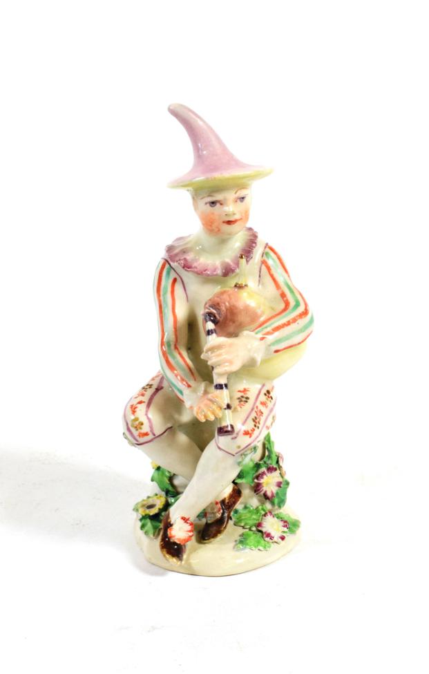 Lot 518 - A Longton Hall Porcelain Commedia dell'Arte Figure of Harlequin, circa 1755, sitting playing...