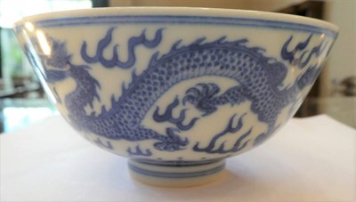 Lot 566 - A Chinese Porcelain Bowl, painted in underglaze blue with dragons chasing the flaming pearl,...