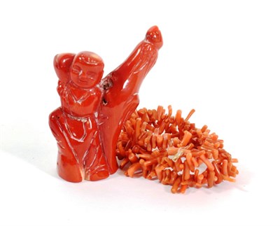 Lot 591 - A Chinese Coral Carving of a Boy, standing beside a tree stump, 7cm high; and A Coral Necklace,...