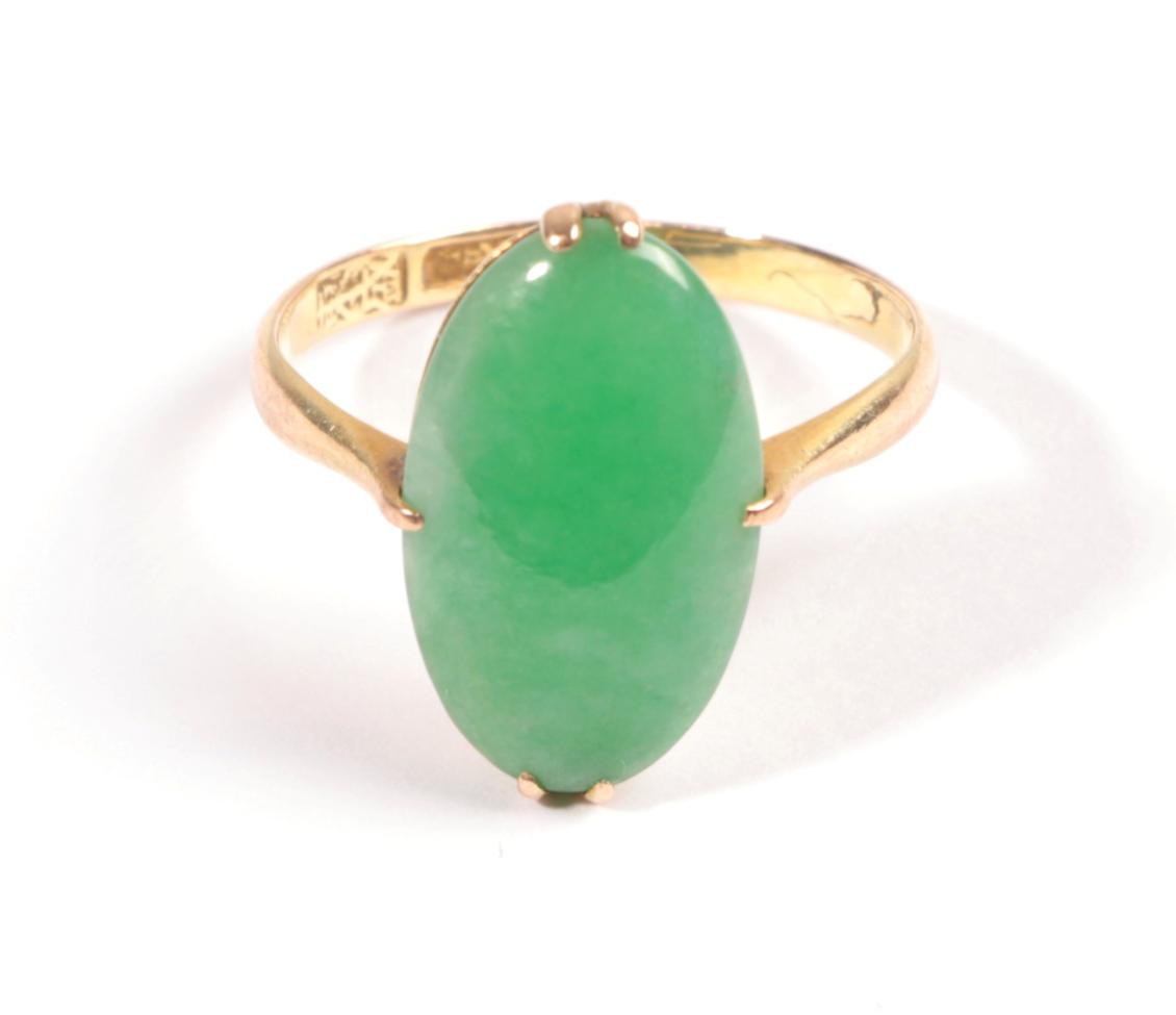 Lot 614 - A Jade Ring, the oval cabochon held in yellow claw, to a tapered shoulder plain polished shank,...