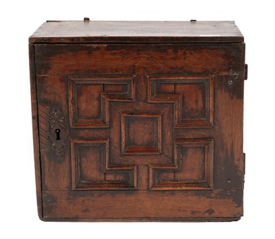 Lot 694 - A 17th Century Oak Spice Cupboard, the geometric moulded door enclosing an arrangement of seven...