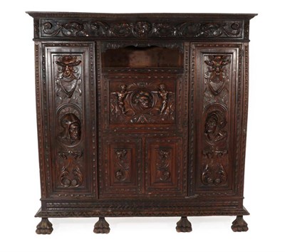 Lot 806 - A Late 19th Century Continental Walnut Cupboard, carved in relief with figural masks and...