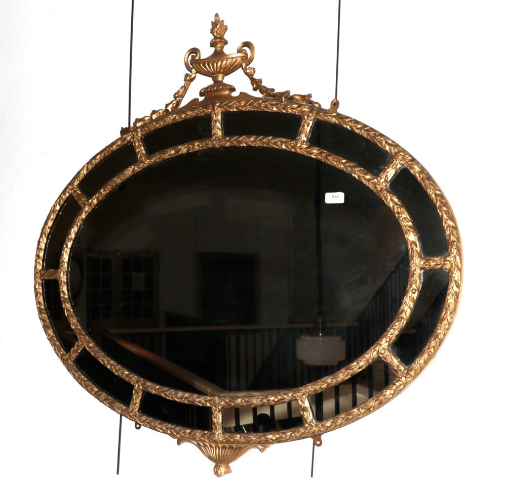 Lot 818 - A 19th Century Gilt and Gesso Adam Style Oval Mirror, the acanthus decorated frame surmounted by an