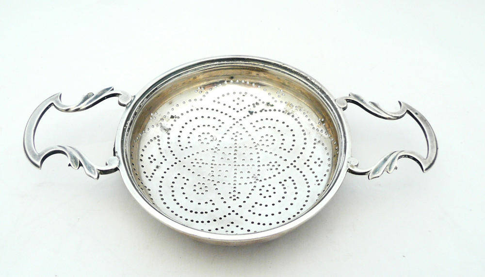 Lot 1150 - A George II Lemon Strainer, Edward Aldridge, London 1751, of circular form with scroll handles...