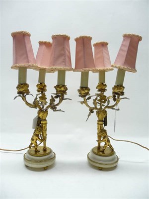 Lot 1187 - A Pair of Gilt Metal Three-Light Candelabra, late 19th/early 20th century, with floriform...