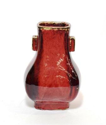 Lot 142 - A Chinese sang de boeuf twin handled faceted baluster vase on rectangular footed base