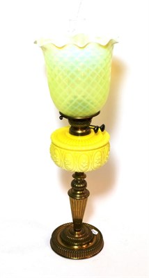 Lot 152 - ^ A late Victorian brass oil lamp with yellow glass reservoir and green vaseline glass shade,...