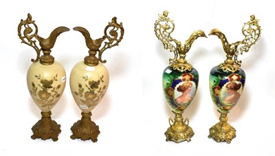 Lot 154 - ^ A pair of late 19th century gilt metal ewers, the porcelain bodies decorated with oval...