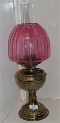 Lot 246 - A Victorian oil lamp, with a cranberry glass shade