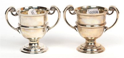 Lot 308 - A pair of late Victorian twin-handled silver cups, maker's mark indistinct, London 1896/97, of 18th