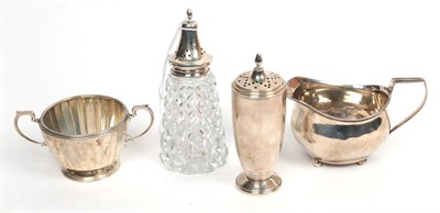 Lot 315 - An Art Deco silver caster, Sanders & Mackenzie, Birmingham 1920; a George III cream jug, London...