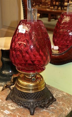 Lot 338 - A brass and patinated metal oil lamp with artichoke form ruby glass shade