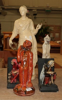 Lot 1095 - An early 20th century orange drip glazed monkey figure; a pair of plaster bookends and a...