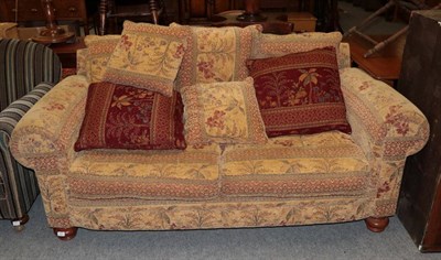 Lot 1208 - A modern two seater sofa upholstered in floral patterned fabric
